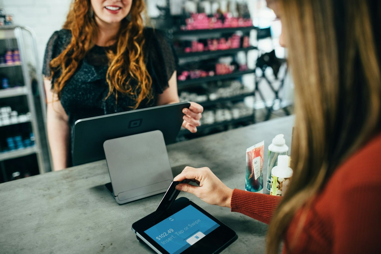 Cliente pagando no balcão de uma loja com o sistema aberto no notebook